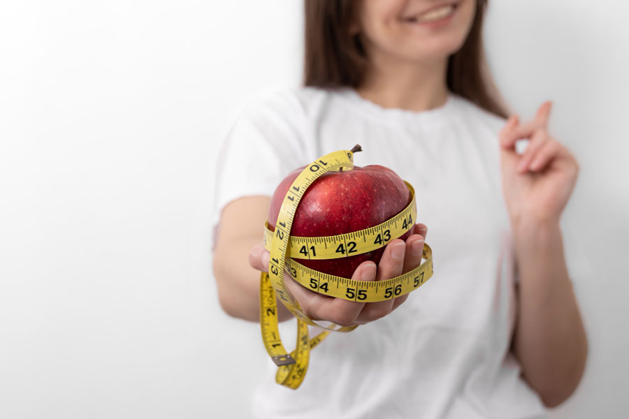 fresh-red-apple-with-measuring-tape-in-female-hands-closeup--Weight-Loss-Miami