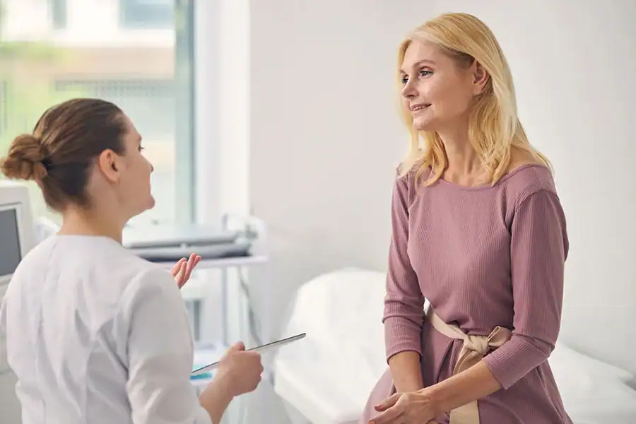 Attentive blonde female person listening to her doctor